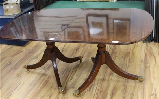 A Regency style mahogany extending twin pillar dining table, L.165cm plus two leaves each 46cm.